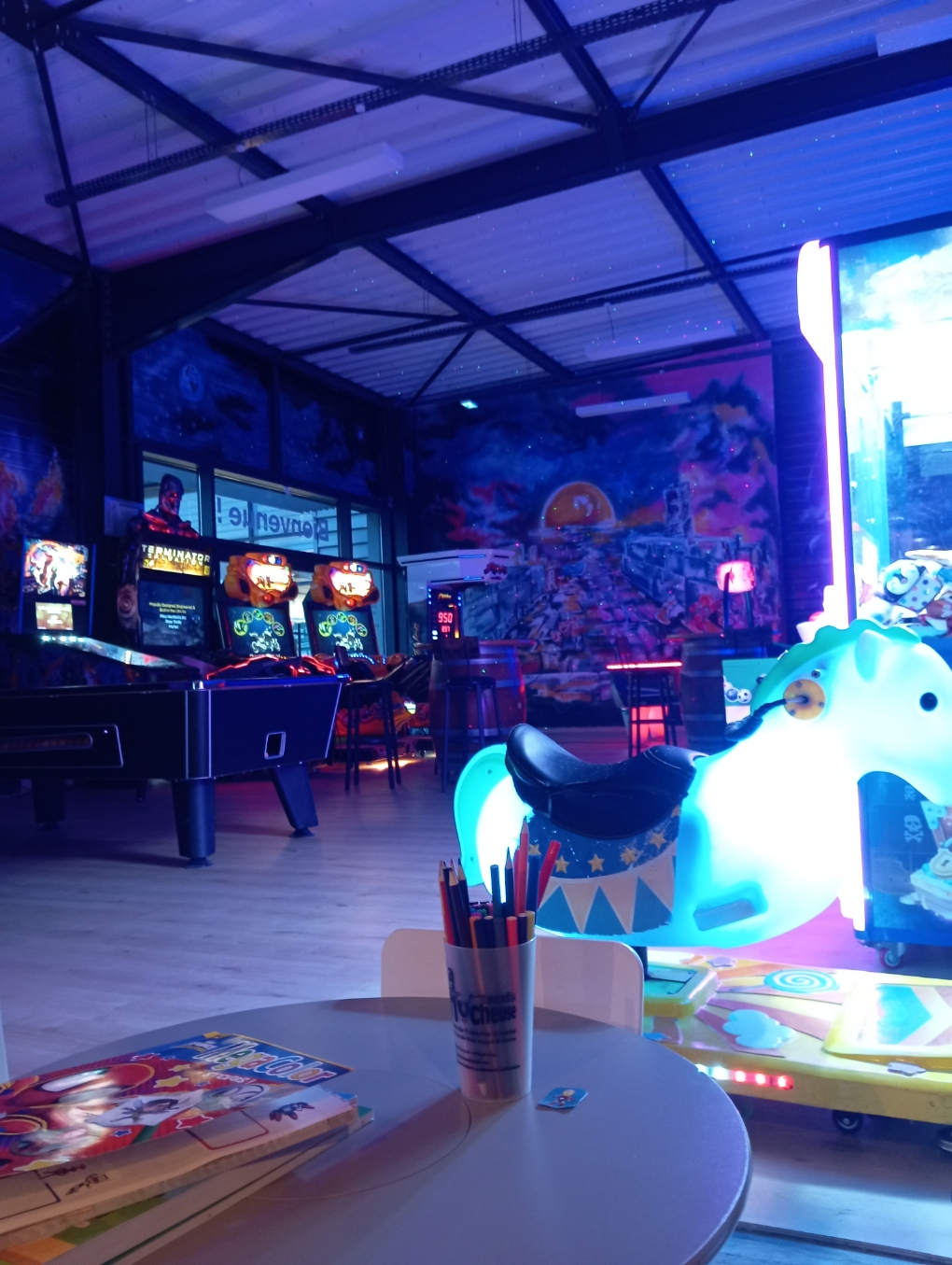 Photo de la partie réservée aux enfants avec une table et des jeux et coloriages